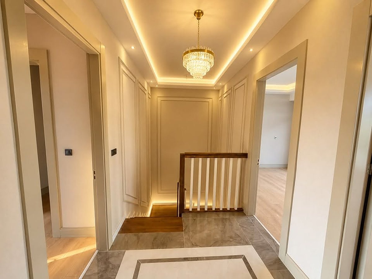 Treppenpodest einer Villa mit Boiserie-Wandpaneelen in Rahmenoptik und Holzhandlauf